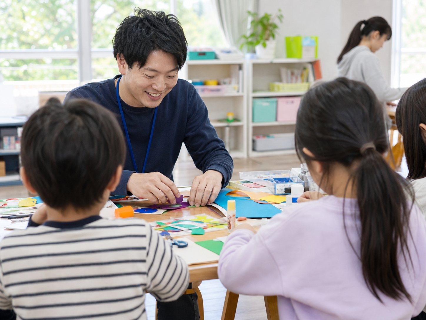 スタッフと一緒に色紙の工作をする子どもたち